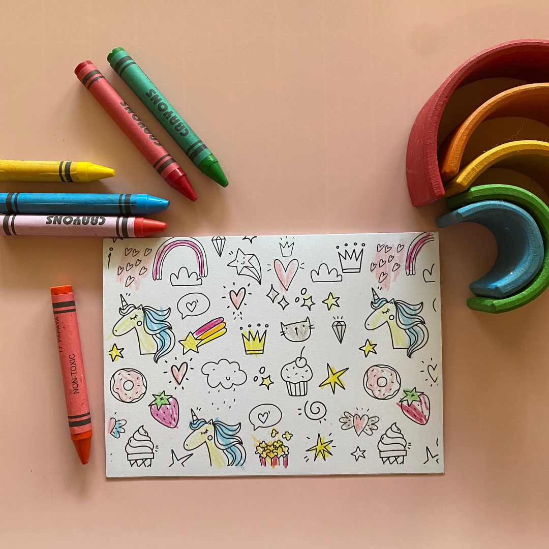 An example of one of our cards coloured in. The design shows unicorns and cupcakes and rainbows and is designed for a kids birthday card.